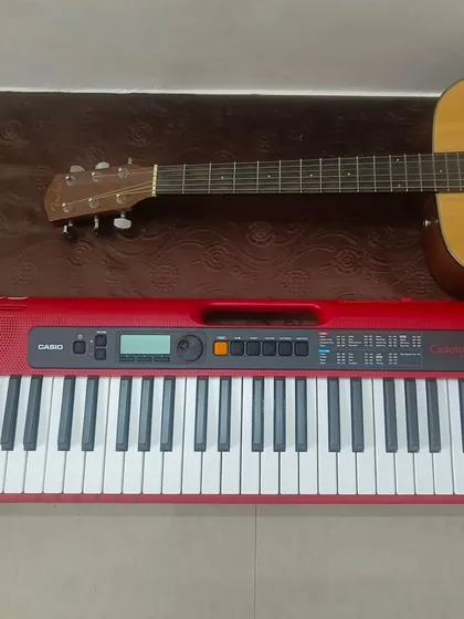A new red Casio keyboard and an acoustic guitar ready for our students. We are constantly updating our instruments at the academy.