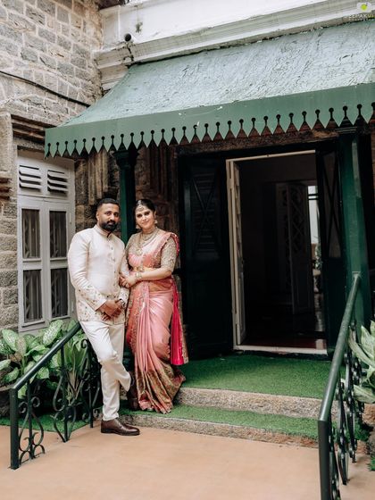 A portrait of us standing outside a heritage building. The classic architecture provides a beautiful backdrop for our traditional yet stylish custom outfits.