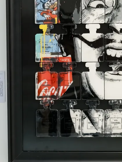 Another detail of "Dali In A Bottle," highlighting the iconic Coca-Cola and Chanel branding that frames the surrealist master's face.