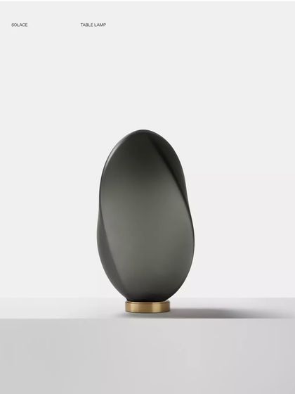 A studio shot of the bronze glass Solace lamp, its swirling, asymmetrical shape creating a captivating sculptural object.