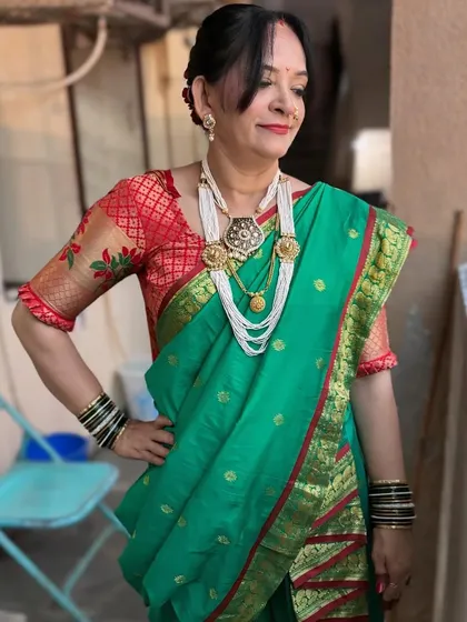 The full Maharashtrian look. The green saree with the red border is a classic combination, and the makeup is kept elegant and timeless.
