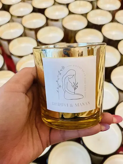 A custom metallic jar candle created for a baby shower. The personalized label features a beautiful illustration and the names of the parents-to-be.