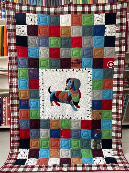 Your memories, stitched with love. This custom T-shirt quilt features a colorful patchwork of treasured shirts, with a special appliqué of the family's beloved dachshund, making it a truly one-of-a-kind keepsake.