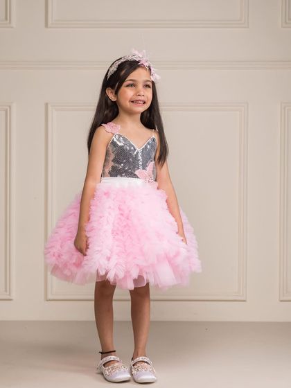 A smiling girl ready for a summer party in our pink and silver tutu dress.