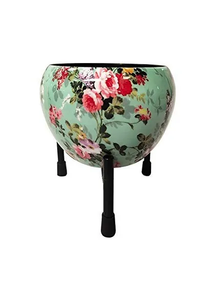This apple-shaped metal pot features a delicate floral print on a mint green background. It comes with a sturdy black stand, offering an elegant and vintage-inspired look for your plants.