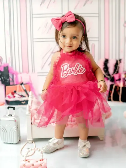 For the little fashionista, my 'Barbie's World' theme is a dream come true. This toddler portrait uses a stylish pink backdrop, chic props, and a fun outfit to celebrate a first birthday in style.