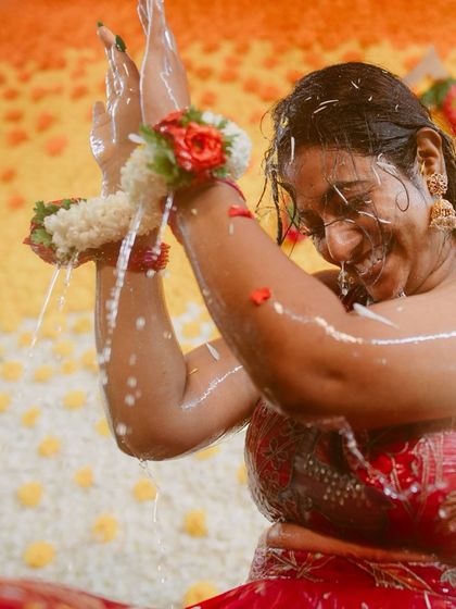 A close-up of the bride during a ritual bath, her expression a mix of joy and reverence.