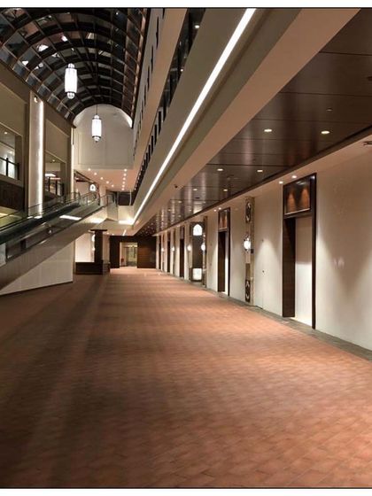 The long corridor of Souq al Madina, showing the blend of traditional lighting fixtures and modern retail design. The space is designed to be both a functional shopping center and a cultural landmark.