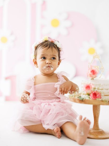 Another adorable shot from this cake smash session. The combination of the pink tutu, the messy frosting, and her focused expression is what makes these photoshoots so memorable.