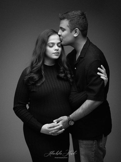 A timeless and intimate black and white portrait. This image focuses purely on the emotion and connection between the expecting couple.