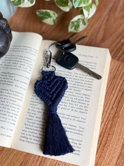 A navy blue heart keychain styled with a book and keys. It's a classic, sophisticated color choice.
