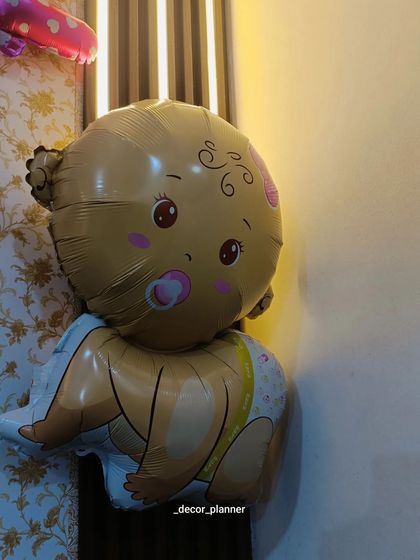 A close-up of the cute baby-shaped foil balloon used in the welcome home decor. These themed balloons are a fun and essential part of creating a baby-focused celebration.