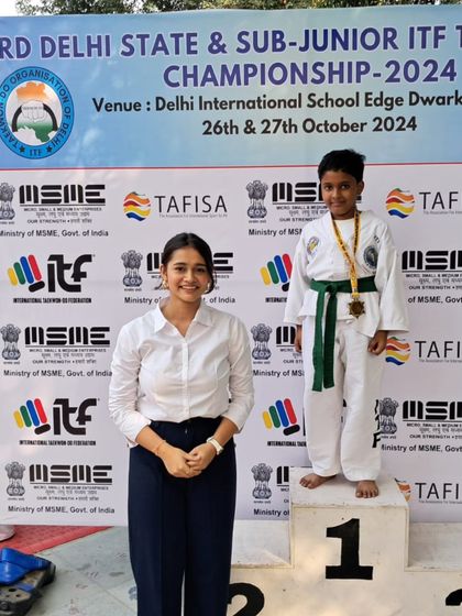A student stands proudly on the first-place podium at the 3rd Delhi State Championship.