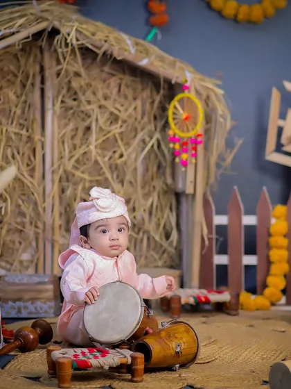A beautiful portrait of a baby with a dhol, capturing the essence of a traditional Lohri celebration in our studio.