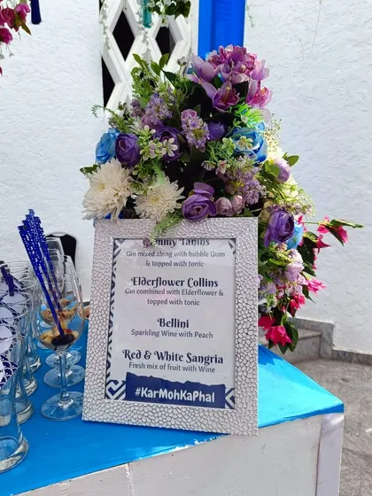 Your custom menu, beautifully displayed. This framed menu showcases the signature cocktails for the event, including the 'Elderflower Collins' and 'Bellini', complete with the couple's wedding hashtag #KarMohKaPhal.