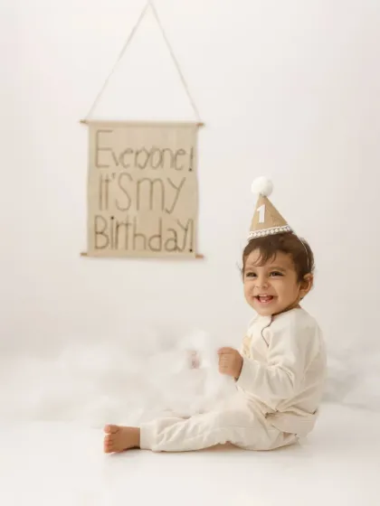 "Everyone! It's my birthday!" This joyful shot captures the excitement of turning one, with a cute party hat and a happy smile.