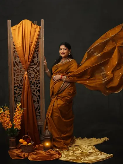 From saree to cradle, the journey of love begins. The flowing pallu of this mustard-colored saree adds a sense of movement and grace to this beautiful solo portrait.