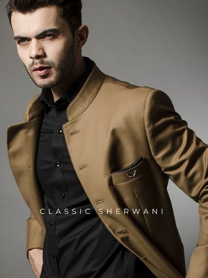 A classic sherwani in a camel color, layered over a black shirt. This look radiates timeless sophistication and is perfect for grand occasions where you want to make a powerful impression.