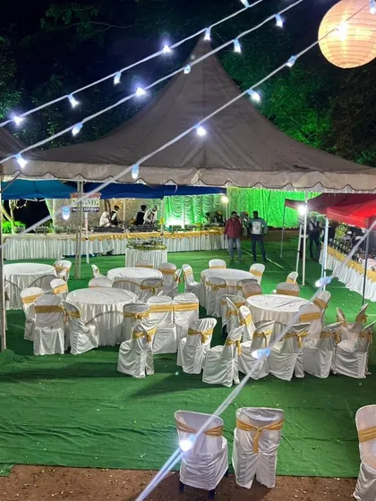 An evening event setup with guest seating and our buffet line visible in the background. We manage the entire catering and seating arrangement to ensure your event runs smoothly from start to finish.