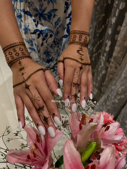 This design combines both the sun and moon motifs for a balanced celestial look. The delicate chains and starbursts on the fingers add a touch of sparkle to this contemporary mehendi.