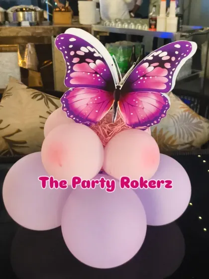 Another example of a butterfly-themed table centerpiece, using pink and purple balloons to match the overall party decor.