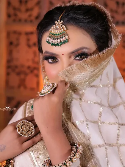 A close-up where the bride's eyes are the main focus, peering over her dupatta.