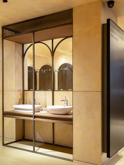 A closer look at a vanity station framed by sleek metalwork. This design uses vertical space effectively and employs mirrors to create a sense of depth in the retail setting.