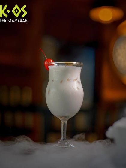 A cocktail so smooth, it feels like a sweet escape. Our creamy Piña Colada is topped with a cherry and served over a dramatic smoky base.