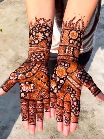 A beautiful example of a 'bel' or vine-style design on the palms, filled with flowers and leaves. The use of bold outlines and delicate shading gives it a lovely texture.