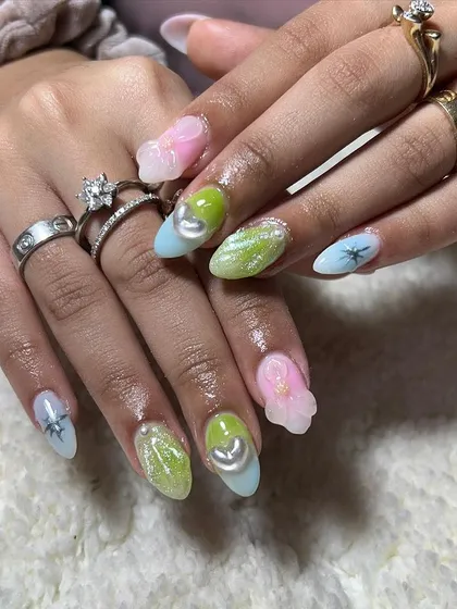 A pastel fantasy set with multi-colored nails, glitter, and 3D elements. This showcases the fun and creative side of nail artistry.
