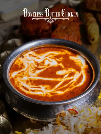 A close-up of the Boneless Butter Chicken from our Akbari Thaal. Notice the rich texture and the swirl of fresh cream, a hallmark of our authentic preparation.