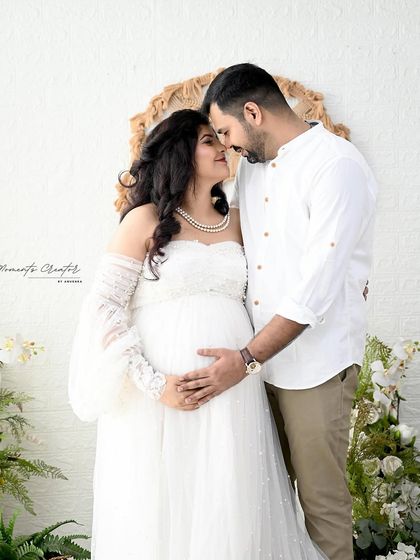 An intimate close-up of the expecting couple. Dressed in classic white, their loving embrace is the centerpiece of this simple and pure portrait.