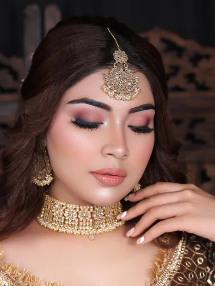 A flawless engagement look with a focus on soft, smokey pink eyes and a nude lip. The makeup perfectly complements the delicate gold jewelry.