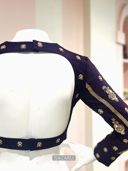 The elegant open-back design of the deep purple raw silk blouse, perfect for pairing with a Kanjeevaram or Benarasi saree.