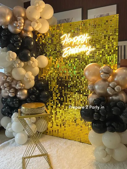 Our gold sequin shimmer wall creates an instant touch of glamour for any event. This popular bachelorette and birthday party setup includes a "Happy Birthday" neon sign and a dramatic balloon garland in a black, white, and gold color scheme.