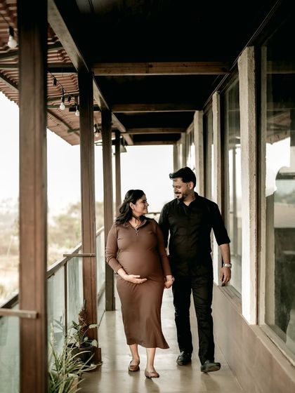 A beautiful portrait of the couple walking along an outdoor corridor, holding hands and looking at each other with love.
