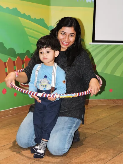 A mother helps her young son with a hula hoop during a fun activity on Mother's Day.