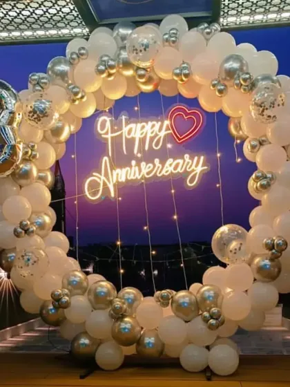 This full circle balloon arch in white and silver is a classic and elegant choice for an anniversary or engagement party backdrop.