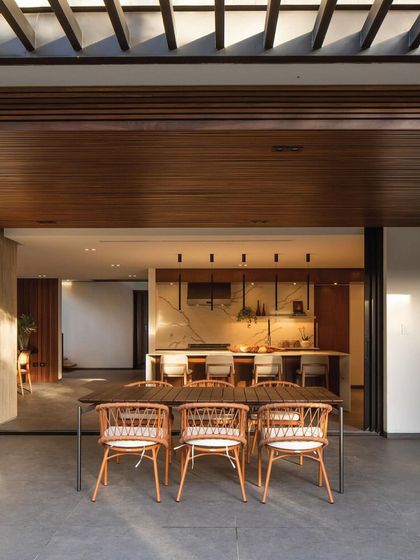 We create a fluid connection between indoor and outdoor living. This covered patio with a large dining table opens directly into the kitchen, making it an ideal setup for hosting and entertaining.