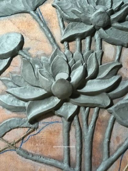 A close up of the initial clay sculpture for the lotus mural. You can see the hand-carved textures on the petals and the use of sutli rope to define the stems, techniques that add depth and realism.
