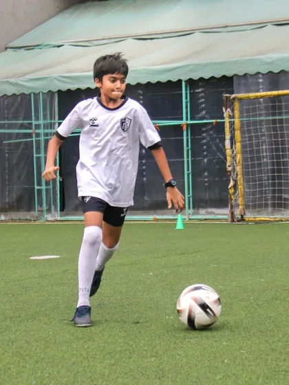 A player runs with the ball at his feet, practicing the skill of dribbling at speed while maintaining control.