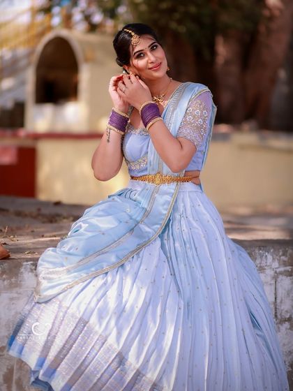 A graceful seated portrait in a beautiful traditional outfit. The outdoor setting adds a touch of realism and charm to this elegant shot.
