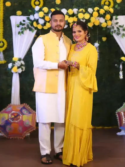 A full-length shot of the couple at their Haldi event, surrounded by beautiful decor.