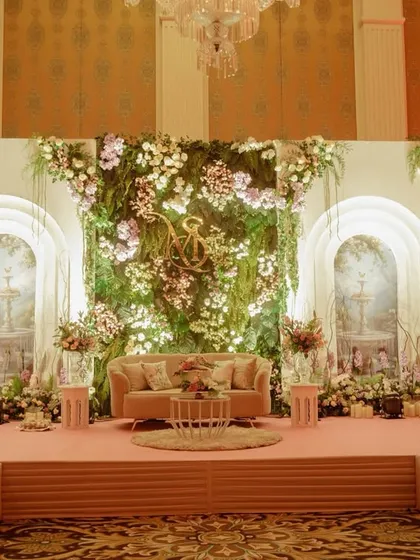 A different view of the indoor garden stage, showing how the elevated platform and soft pink flooring made the romantic floral backdrop even more of a centerpiece.