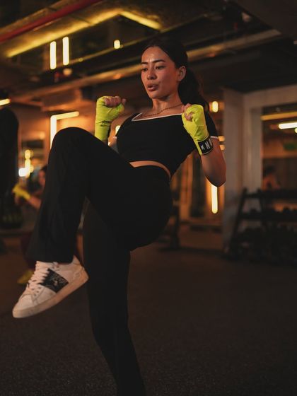 Our group classes are designed to empower you. Here, a member warms up with knee raises, getting ready for a high-energy session that combines elements of cardio and bodyweight conditioning.