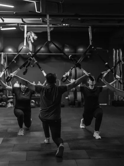Our group works on TRX lunges, a fantastic exercise for challenging balance and building unilateral leg strength. The synchronized movement shows the collective energy of our classes.