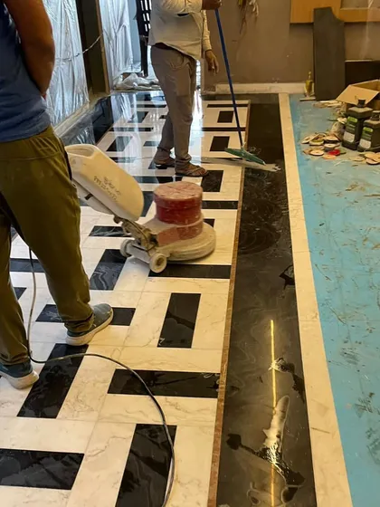 The polishing process for a newly installed Italian marble floor. This step is crucial for achieving the high-gloss, luxurious finish seen in the final project.