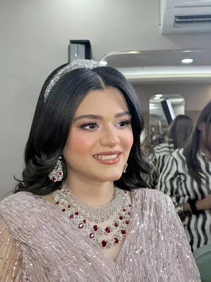 A close-up of the makeup, featuring a soft pink and brown eye look and a glossy lip.