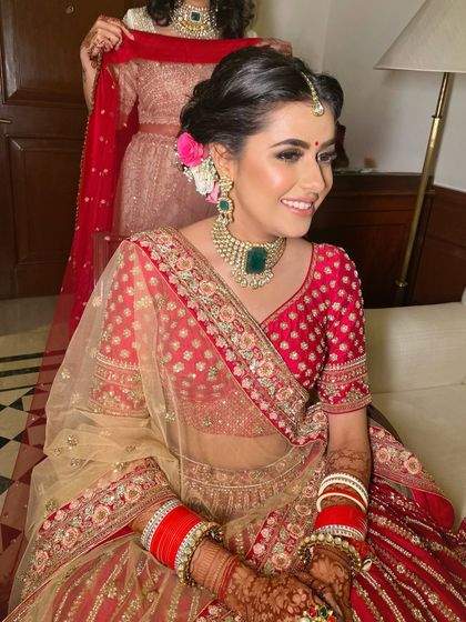 The joy on a bride's face is everything. I created a fresh and radiant look for her, with a pop of pink on the cheeks and a messy floral bun to complete the style.