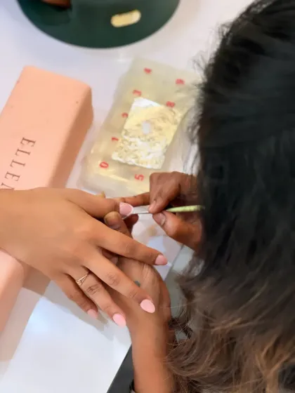 The process starts with meticulous prep work. Here, I am carefully tending to the cuticles to create a clean and healthy base before applying any polish or extensions.